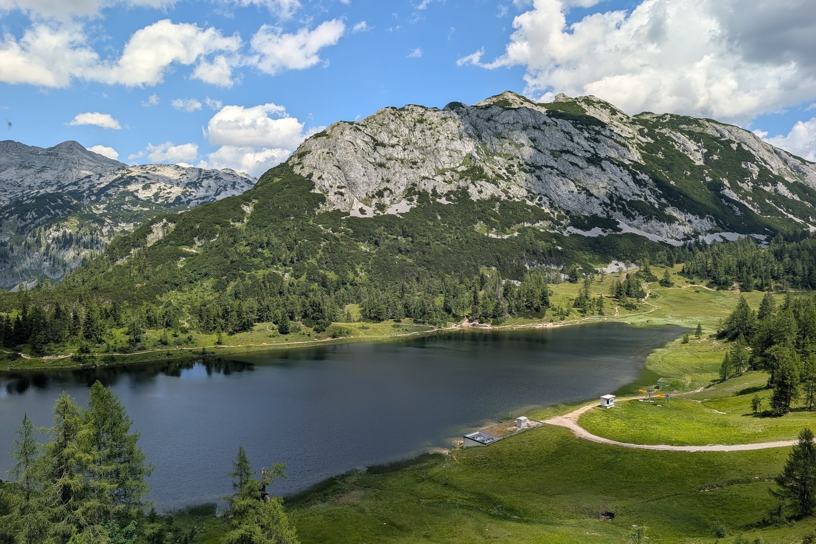 Der Großsee auf der Tauplitzalm vor hellen Kalkfelsen und grünen Almwiesen